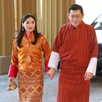 Untuk acara tersebut, keduanya memilih baju tradisional nuansa merah-kuning. Penampilan Jetsun Pema kembali menarik perhatian, tidak lain karena keindahan kain warna-warni yang dikenakannya sebagai bawahan. Foto: Getty Images