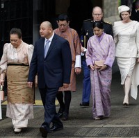 Raja Jigme memakai busana tradisional pria Bhutan yang disebut Gho. Pakaian terbuat dari kain tenun itu bermotif garis-garis, dipadukan sabuk bernama Kera yang dililitkan di pinggang. Foto: Getty Images
