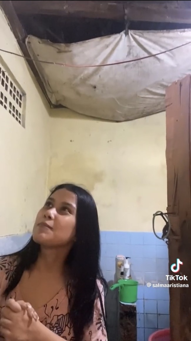 Mendengar penjelasan Salma seketika rumah yang reyot itu jadi terasa seperti sebuah istana. Ketika me-review kamar mandi di dalam rumah Salma mengatakan bahwa kamar mandi yang pintunya dikaitkan menggunakan tali itu sudah dilengkapi dengan teknologi smart lock. Di bagian dalam kamar mandi juga terdapat shower alami dan pertunjukkan air terjun yang bisa dinikmati saat hujan. Foto: TikTok/@salmaaristiana
