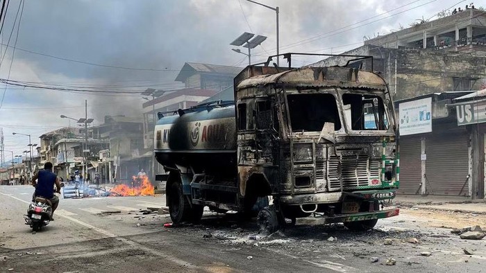 A scooterist rides past a damaged water tanker that was set afire during a protest by tribal groups in Churachandpur in the northeastern state of Manipur, India, May 4, 2023. REUTERS/Stringer/File Photo