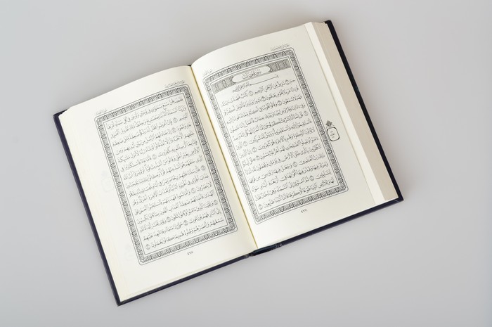 Muslim woman reading from the Quran. She was wearing a polite Abaya Muslim dress.