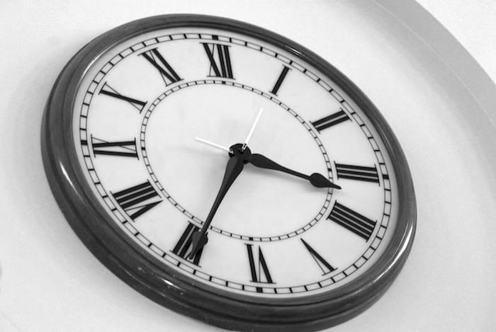 Jam dinding dengan bilangan romawi.
