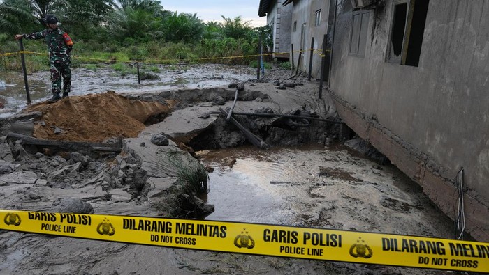 Tiga aparatur pemerintah berdiri di jendela bangunan laboratorium yang terkena ledakan semburan lumpur panas di Pondok Pesantren Nurul Alamiyyah di Wajok Hilir, Kecamatan Jungkat, Kabupaten Mempawah, Kalimantan Barat, Senin (8/5/2023). Semburan lumpur panas tersebut terjadi setelah pihak pondok pesantren melakukan pengeboran tanah sedalam 40 meter untuk mendapatkan sumber air bersih yang kemudian terjadi ledakan yang menghantam bangunan laboratorium. ANTARA FOTO/Jessica Helena Wuysang/tom.