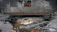 Tiga aparatur pemerintah berdiri di jendela bangunan laboratorium yang terkena ledakan semburan lumpur panas di Pondok Pesantren Nurul Alamiyyah di Wajok Hilir, Kecamatan Jungkat, Kabupaten Mempawah, Kalimantan Barat, Senin (8/5/2023).  