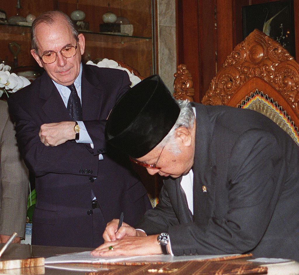 Foto arsip 15 Januari 1998 ini menunjukkan Presiden Indonesia saat itu Suharto menandatangani surat perjanjian baru di hadapan Direktur Jenderal Dana Moneter Internasional (IMF) Michel Camdessus di kediaman Suharto di Jakarta. Suharto menandatangani surat yang menguraikan reformasi besar-besaran dan langkah-langkah penghematan terkait dengan bailout besar-besaran yang dipimpin oleh IMF. Sepuluh tahun setelah memainkan peran kontroversial dalam krisis keuangan Asia, Dana Moneter Internasional (IMF) kini berada di tengah krisis identitasnya sendiri. Lembaga berusia enam dekade, yang meminjamkan lebih dari USD 38 miliar selama periode dua tahun ke negara-negara Asia dengan syarat mereka mengadopsi langkah-langkah penghematan yang ketat, mendapati dirinya 10 tahun kemudian dijauhi oleh banyak negara yang sebelumnya telah dibantu. (File Foto - AGUS LOLONG/AFP via Getty Images)