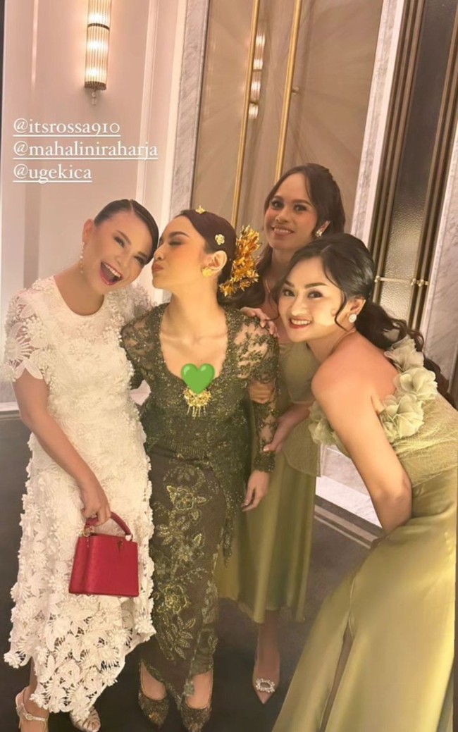 Rossa menghampiri Mahalini langsung saat acara lamarannya. Juri Indonesian Idol X itu memakai gaun brokat putih dengan sentuhan merah dari tasnya. Foto: Instagram