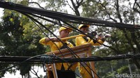 Petugas Dinas Bina Marga memotong kabel udara utilitas di Jalan Jenderal Sudirman, Jakarta, Selasa (9/5/2023).