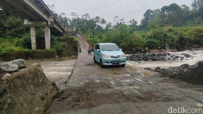 Kendaraan terpaksa melewati cekdam karena amblasnya Jembatan Cidugaleun, Tasikmalaya