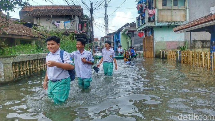 Para pelajar menerjang banjir demi bisa sampai ke sekolah.