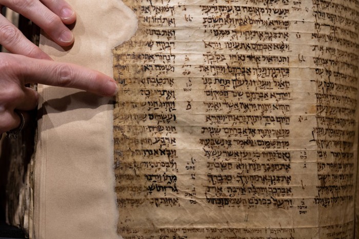 NEW YORK, NEW YORK - MAY 08: People view The Codex Sassoon while on display during a press preview at Sotheby's on May 08, 2023 in New York City. The codex is the oldest surviving Hebrew Bible or Tanakh as its used today in contrast to the dead sea scrolls which are older but the books are in separate scrolls. The Book is approximately 1000 years old and is estimated to be auctioned at 30-50 Million dollars and that would make it the most valuable historical document to appear in auction. (Photo by Alexi Rosenfeld/Getty Images)