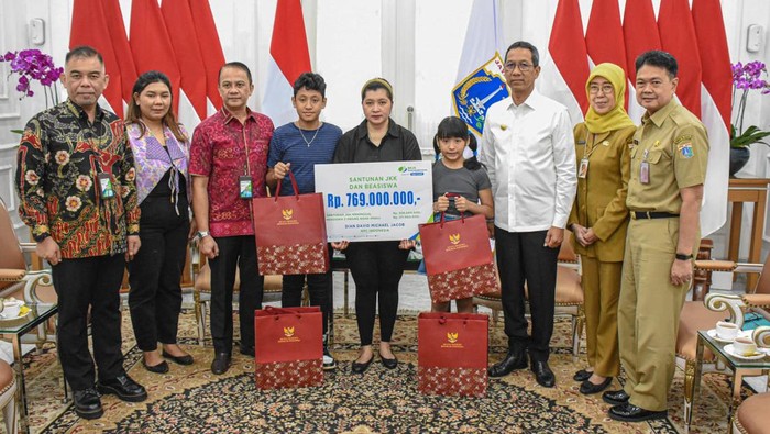 Penjabat Gubernur DKI Jakarta Heru Budi Hartono menyerahkan santunan kecelakaan kerja kepada keluarga mendiang David Jacobs.