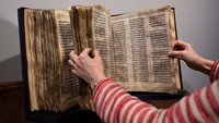 Seorang ahli seni memegang The Codex Sassoon saat dipajang selama pratinjau pers di rumah lelang Sothebys, New York City, Amerika Serikat, Senin (8/5/2023).  