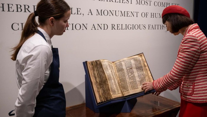 NEW YORK, NEW YORK - MAY 08: Sharon Mintz (R), Sotheby's senior Judaica specialist for books and manuscripts, looks through the Codex Sassoon during a press preview of at Sotheby's on May 08, 2023 in New York City. The codex is the oldest surviving Hebrew Bible or Tanakh as its used today in contrast to the dead sea scrolls which are older but the books are in separate scrolls. The Book is approximately 1000 years old and is estimated to be auctioned at 30-50 Million dollars and that would make it the most valuable historical document to appear in auction. (Photo by Alexi Rosenfeld/Getty Images)