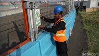 Petugas tengah memasang dan mengecek tanda-tanda untuk memundahkan penonton.