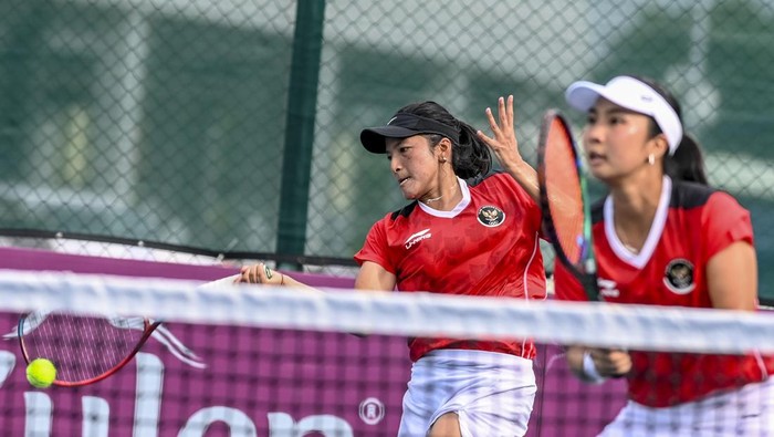 Tenis beregu putri Indonesia meraih medali emas Petenis ganda putri Indonesia Aldila Sutjiadi (kanan) dan Jessy Rompie (kiri) mengembalikan bola ke arah petenis ganda putri Thailand Luksika Kumkum dan Peangtarn Plipuech pada pertandingan final beregu tenis SEA Games 2023 di Tennis Arena, Morodoc Techo National Stadium, Phnom Penh, Kamboja, Selasa (9/5/2023). Aldila dan Jessy menang dengan skor 6-3 dan 7-5, sehingga tim tenis putri Indonesia mendapatkan medali emas. ANTARA FOTO/Muhammad Adimaja/YU
