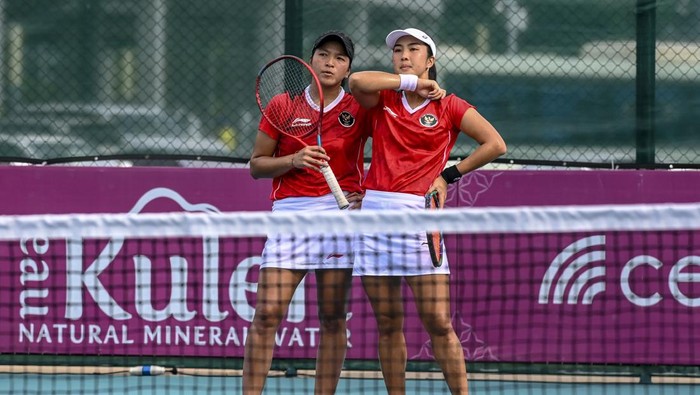 Tenis beregu putri Indonesia meraih medali emas Petenis ganda putri Indonesia Aldila Sutjiadi (kanan) dan Jessy Rompie (kiri) mengembalikan bola ke arah petenis ganda putri Thailand Luksika Kumkum dan Peangtarn Plipuech pada pertandingan final beregu tenis SEA Games 2023 di Tennis Arena, Morodoc Techo National Stadium, Phnom Penh, Kamboja, Selasa (9/5/2023). Aldila dan Jessy menang dengan skor 6-3 dan 7-5, sehingga tim tenis putri Indonesia mendapatkan medali emas. ANTARA FOTO/Muhammad Adimaja/YU