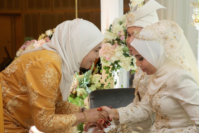 A pair of newlywed Muslim bride and groom receives blessing from mother of the bride in wedding reception, Kuala Lumpur Malaysia.