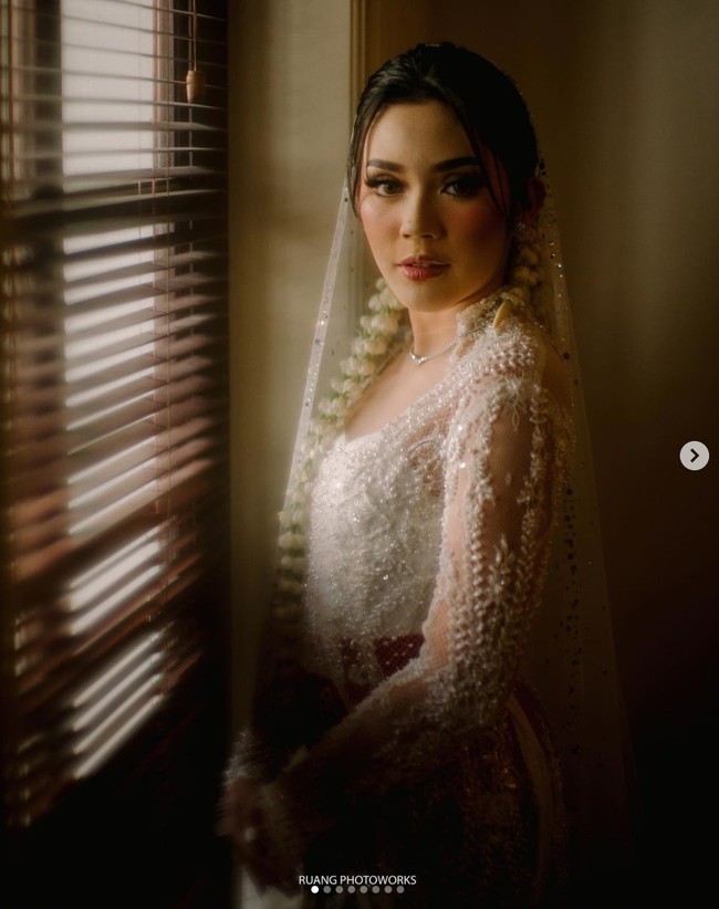 Fay Nabila tampak begitu cantik dan anggun mengenakan kebaya berwarna putih yang dipadukan dengan ikat pinggang merah. Penampilannya makin menawan dengan ronce melati di kepalanya dan riasan wajah. Foto: Instagram/@ruangphotoworks
