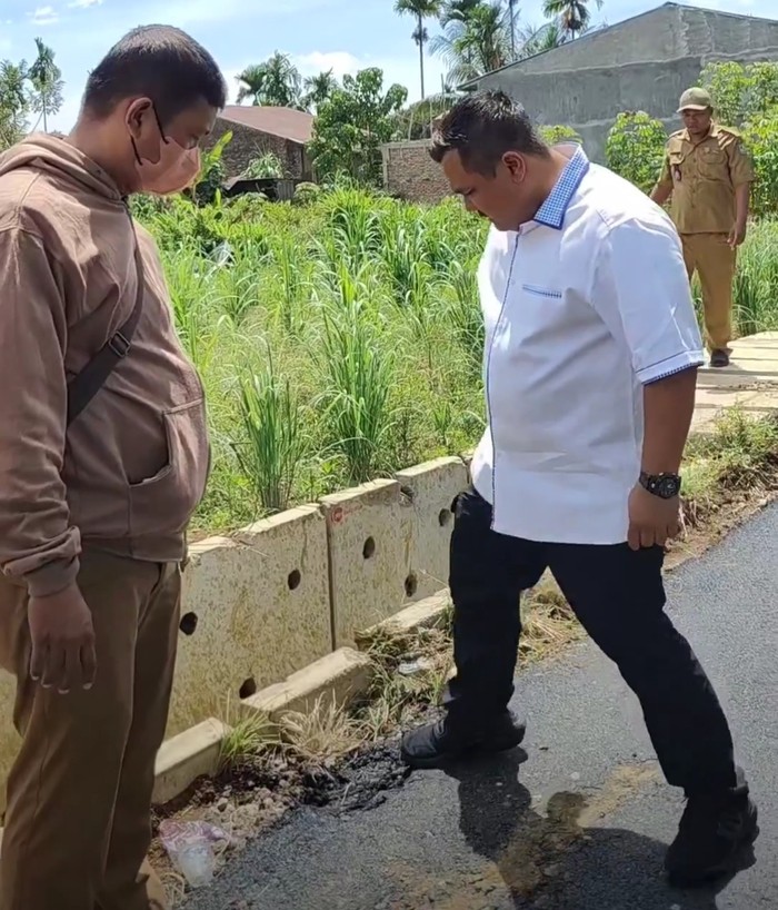 Kadis SDABMBK Medan Topan Ginting saat menginjak aspal Jalan Bunga Rampai III yang baru dikerjakan hingga terkelupas. (Instagram @dinaspukotamedan)