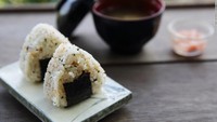 Onigiri, nasi Jepang yang dikukus yang dibentuk menjadi bentuk segitiga dan dibungkus dengan rumput laut yang disebut nori.
