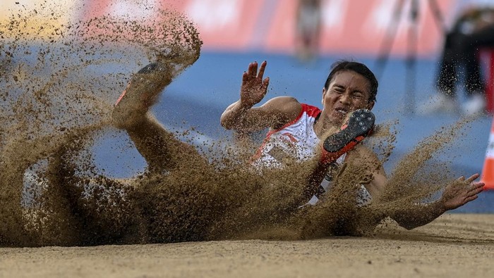 Atlet Indonesia Maria Natalia Londa mengibarkan bendera merah putih usai memastikan meraih medali emas pada nomor lompat jauh putri SEA Games 2023 di Stadion Morodok Techo National Stadium, Kamboja, Rabu (10/5/2023). Maria Natalia Londa berhasil merebut medali emas usai melakukan lompatan terjauh  6,28 meter pada percobaan kelima diikuti dua atlet Vietnam Thi Thu Thoa Bui di peringkat kedua dengan 6,13 meter dan Thi Loan Bui yang meraih perunggu dengan 6,02 meter. ANTARA FOTO/Muhammad Adimaja/aww.