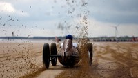 Nampak sebuah mobil klasik dipacu dengan kencang di pantai.  