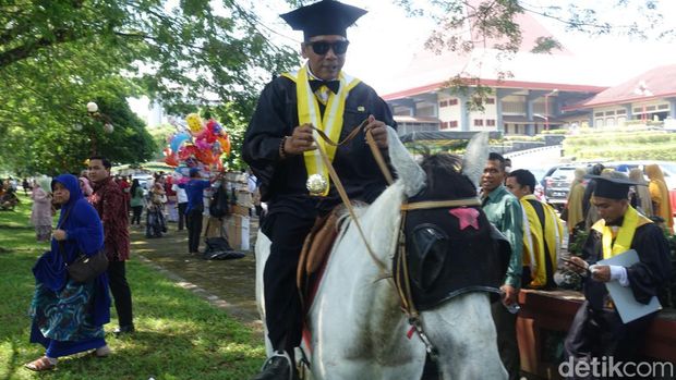 Momen Endra Harsaya, mahasiswa program pasca sarjana UGM menaiki kuda usai upacara wisuda, Rabu (10/5/2023).