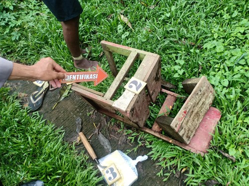 Polisi melakukan identifikasi pada kursi kayu yang rebah dan diduga dipakai DK saat gantung diri di ladang milik orang tuanya. (istimewa)
