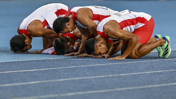 Tim estafet putra Indonesia raih medali emas SEA Games Tim pelari estafet 4X100M putra Indonesia (dari kiri) Bayu Kertanegara, Wahyu Setiawan, Sudirman Hadi dan Lalu Muhammad Zohri berpose dengan membawa bendera Merah Putih usai final nomor lari estafet SEA Games 2023 di Stadion Morodok Techo National Stadium, Phnom Penh, Kamboja, Rabu (10/5/2023). Tim estafet putra Indonesia berhasil meraih medali emas dengan catatan waktu tercepat 39,110 detik diikuti tim estafet putra Thailand (39,130 detik) dan tim estafet putra Malaysia (39,360 detik). ANTARA FOTO/Muhammad Adimaja/aww.