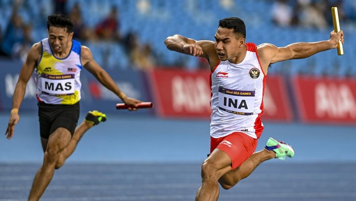 Tim estafet putra Indonesia raih medali emas SEA Games Tim pelari estafet 4X100M putra Indonesia (dari kiri) Bayu Kertanegara, Wahyu Setiawan, Sudirman Hadi dan Lalu Muhammad Zohri berpose dengan membawa bendera Merah Putih usai final nomor lari estafet SEA Games 2023 di Stadion Morodok Techo National Stadium, Phnom Penh, Kamboja, Rabu (10/5/2023). Tim estafet putra Indonesia berhasil meraih medali emas dengan catatan waktu tercepat 39,110 detik diikuti tim estafet putra Thailand (39,130 detik) dan tim estafet putra Malaysia (39,360 detik). ANTARA FOTO/Muhammad Adimaja/aww.