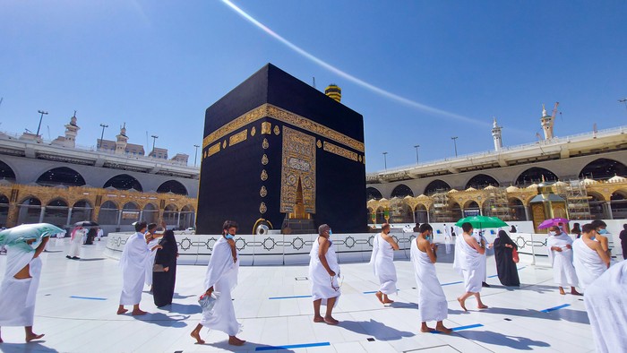 MECCA, SAUDI ARABIA , OCTOBER 22, 2020 - Pilgrims circle the Kaaba in Masjid al-Haram - umrah Fewer Muslims people Socially Distanced corona virus wearing face mask