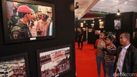 Humas PENA 98 M. Sopiyan (berjaket hitam) memberikan penjelasan kepada pengunjung dari deretan foto gerakan mahasiswa 1998 pada Pameran Foto 25 Tahun Reformasi di Graha PENA 98, Jakarta, Kamis (11/5/2023).