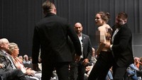 Wanita itu menyela pidato CEO Porsche Oliver Blume sebelum akhirnya dibawa pergi oleh petugas keamanan. Foto: AFP/TOBIAS SCHWARZ