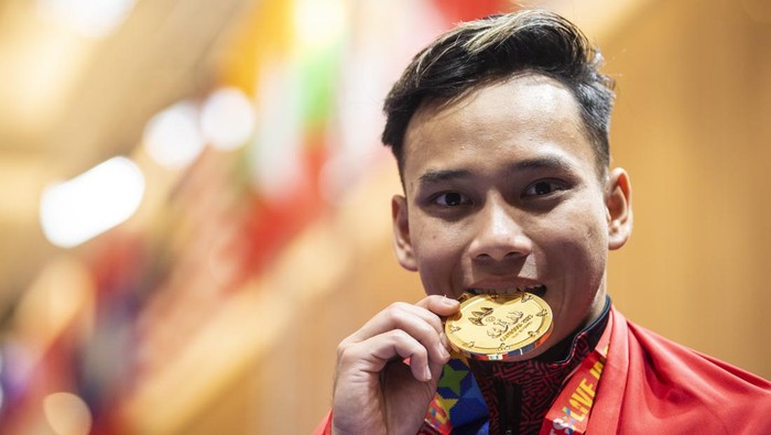 Atlet Taolu Indonesia Muhammad Daffa Golden Boy menggigit emas seusai upacara penghargaan pemenang babak final nomor Jianshu-Qiangshu putra SEA Games 2023 di Chroy Changvar International Convention & Exhibition Center, Phnom Penh, Kamboja, Kamis (11/5/2023). Daffa Golden Boy meraih medali emas pada nomor tersebut dengan total poin tertinggi 19.3260. ANTARA FOTO/M Agung Rajasa/YU