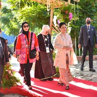 Kebaya Iriana Jokowi dalam potongan kutubaru yang dilengkapi selendang senada. Kainnya sendiri menggunakan tenun NTT yang khas dengan motif geometrisnya, tapi kali ini tampak terasa lebih modern berkat warna pastel dan motif orang-orangannya. (Foto: Handout/Anadolu Agency via Getty Images)