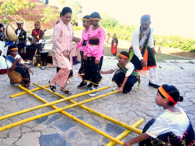 Iriana Jokowi bahkan sempat unjuk kebolehan bermain Rangku Alu. Kebaya nyatanya tak mengurangi kelincahan Ibu Negara RI. (Foto: Dok. BPMI Setpres RI)