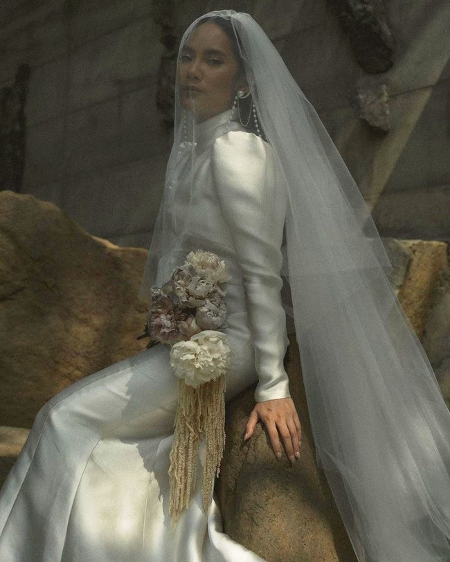 Super simpel, gaun pengantin tertutup yang dikenakan Tara Basro saat menikah dengan Daniel Adnan juga tak kalah mencuri atensi. Gaun putih panjang dengan kerah tinggi itu tampak polos tanpa adanya brokat ataupun bordiran. Gaun tersebut kemudian dipadukan Tara Basro dengan veil panjang dan aksesori perhiasan mutiara. Foto: Instagram/@tarabasro