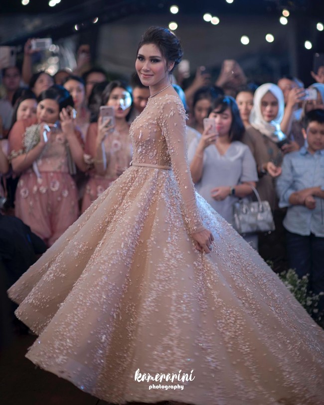 Tak selalu putih, Syahnaz Sadiqah memilih mengenakan gaun pengantin ball gown berwarna salem di hari pernikahannya. Gaun cantik tersebut berhasil menyulap Syahnaz hingga terlihat bak princess di hari bahagianya. Rambutnya juga tampak simpel dengan hanya dikonde ke belakang. Foto: Instagram/@syahnazs