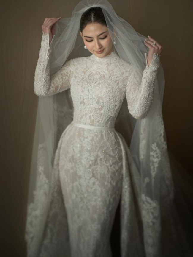 Jessica Mila yang baru saja menggelar pernikahan dengan Yakup Hasibuan memilih untuk mengenakan gaun pengantin yang tertutup. Gaun pengantin panjang yang dipenuhi brokat itu tampak cantik membentuk tubuhnya. Penampilannya kian menawan ditambah dengan veil yang cukup panjang. Sepintas Jessica mengingatkan pada Grace Kelly saat menikah dengan Pangeran Rainier III dari Monako pada 1956 silam. Foto: Instagram/@yeftagunawan