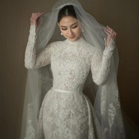 Jessica Mila yang baru saja menggelar pernikahan dengan Yakup Hasibuan memilih untuk mengenakan gaun pengantin yang tertutup. Gaun pengantin panjang yang dipenuhi brokat itu tampak cantik membentuk tubuhnya. Penampilannya kian menawan ditambah dengan veil yang cukup panjang. Sepintas Jessica mengingatkan pada Grace Kelly saat menikah dengan Pangeran Rainier III dari Monako pada 1956 silam. Foto: Instagram/@yeftagunawan