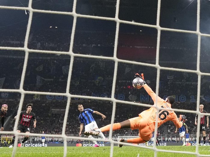 AC Milan's goalkeeper Mike Maignan, right, fails to save the ball as Inter Milan's Henrikh Mkhitaryan, second right, scores his side's second goal during the Champions League semifinal first leg soccer match between AC Milan and Inter Milan at the San Siro stadium in Milan, Italy, Wednesday, May 10, 2023. (AP Photo/Antonio Calanni)