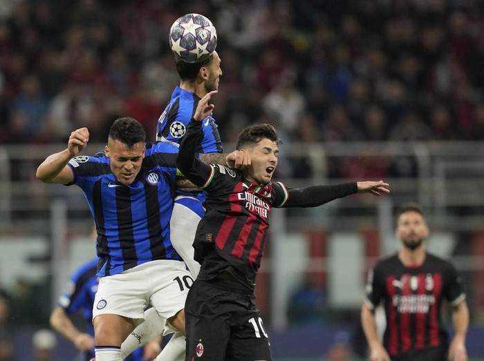 Inter Milan's Hakan Calhanoglu, top, heads the ball past AC Milan's Brahim Diaz, right, and his teammate Lautaro Martinez during the Champions League semifinal first leg soccer match between AC Milan and Inter Milan at the San Siro stadium in Milan, Italy, Wednesday, May 10, 2023. (AP Photo/Antonio Calanni)