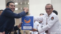Ketua Badan Pemenangan Pemilu Partai NasDem Prananda Surya Paloh memberikan berkas pendaftaran NasDem kepada Ketua KPU Hasyim Asyari sebagai simbolis.  