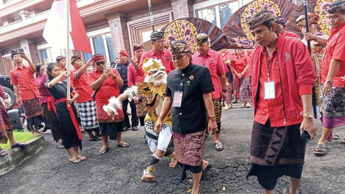 Ketua DPC PDIP Badung I Nyoman Giri Prasta dikawal hanoman saat jalan kaki menyerahkan berkas pendaftaran Bacaleg ke KPU Badung, Kamis (11/5/2023).