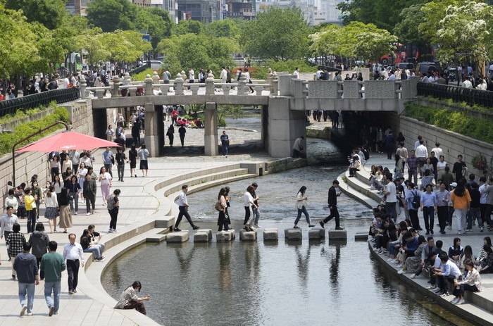 People walk along the public area of the Cheonggye Stream in Seoul, South Korea, Thursday, May 11, 2023. South Korea will drop its COVID-19 quarantine requirements and end testing recommendations for international arrivals starting next month after the World Health Organization declared the end of the global health emergency. (AP Photo/Ahn Young-joon)