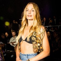 Margot Robbie menambahkan vest emas di atas bikini sebagai aksen yang membuat gayanya lebih stylish. Foto: Getty Images