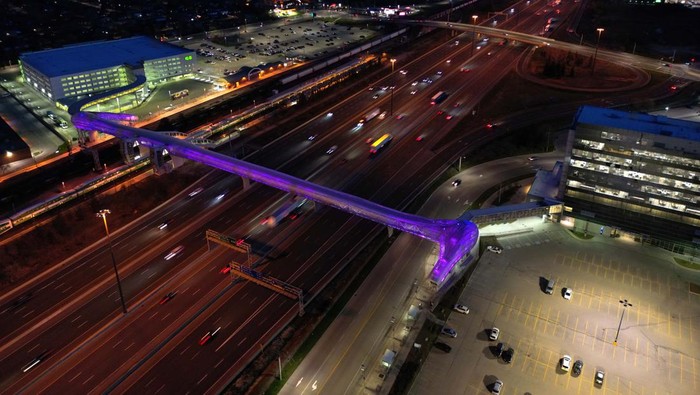 PICKERING, ONTARIO - APRIL 27 : Aerial view of cars and trucks pass under Pickering pedestrian bridge at night on Highway 401 in Pickering, Ontario on April 27, 2023. Guinness World Record holder Pickering pedestrian bridge, located 45 minutes east of Toronto, in the City of Pickering, Ontario, Canada was completed in September 2018. The 250-meter bridge stretches across 14 lanes of Highway 401, six active railway tracks, and a two-lane local road. Additionally, it features nearly 300 LED lights that illuminate it beautifully at night. (Photo by Mert Alper Dervis/Anadolu Agency via Getty Images)