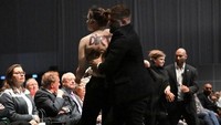 Badan belakang wanita itu dicoret dengan tulisan “Dirty Money”. Para demonstran berpendapat, Volkswagen, sebagai salah satu pembuat mobil terbesar di dunia, menghasilkan sebagian besar keuntungannya dari kendaraan yang menyebabkan kerusakan lingkungan. Volkswagen juga terlibat skandal dieselgate, ditemukan kecurangan dalam uji emisi dan berkontribusi dalam memperpendek umur manusia secara global. Foto: AFP/TOBIAS SCHWARZ