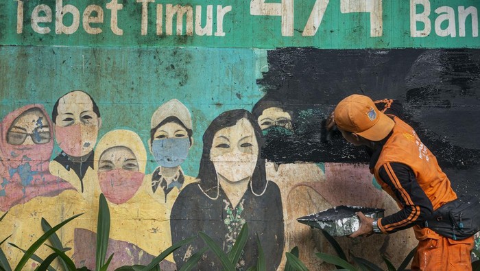 WHO Cabut Darurat Covid-19, Mural Soal Masker di Jakarta Mulai Dihapus Municipal worker removed a mural promoting awareness of the coronavirus disease (Covid-19) and replaced it with another image in Jakarta, Indonesia, on May 09, 2023. The World Health Organization (WHO) has declared that Covid-19 is over as a global health emergency. But they warned that the decision to lift the emergency did not signal an end to the pandemic, and cautioned countries not to take this as a reason to dismantle the Covid response system. The Indonesian Ministry of Health is preparing to make the transition from pandemic to endemic (Photo by Agoes Rudianto/NurPhoto via Getty Images)