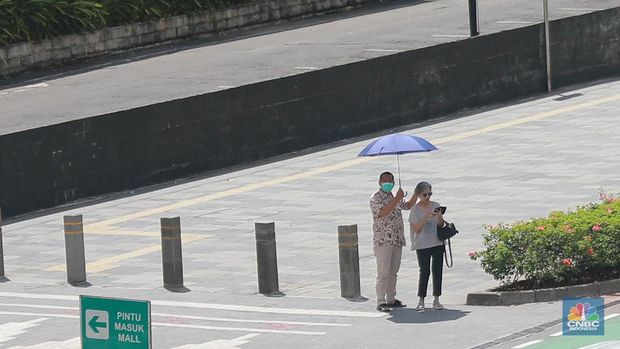 Sejumlah pekerja melintas di jalur pedestrian di kawasan Senayan Sudirman, Jakarta, Jumat (12/5/2023). (վ/Muhammad Sabki)